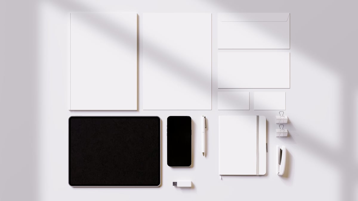 Brand identity stationery mockup showing logo applied across business cards, signage and digital devices