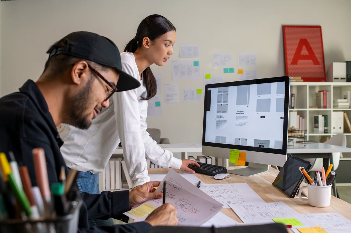 Website designers reviewing wireframes and user flow sketches for a new site