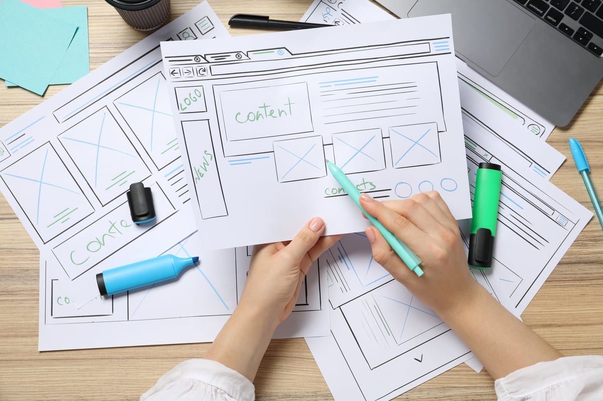 Website designer sketching a wireframe layout on paper