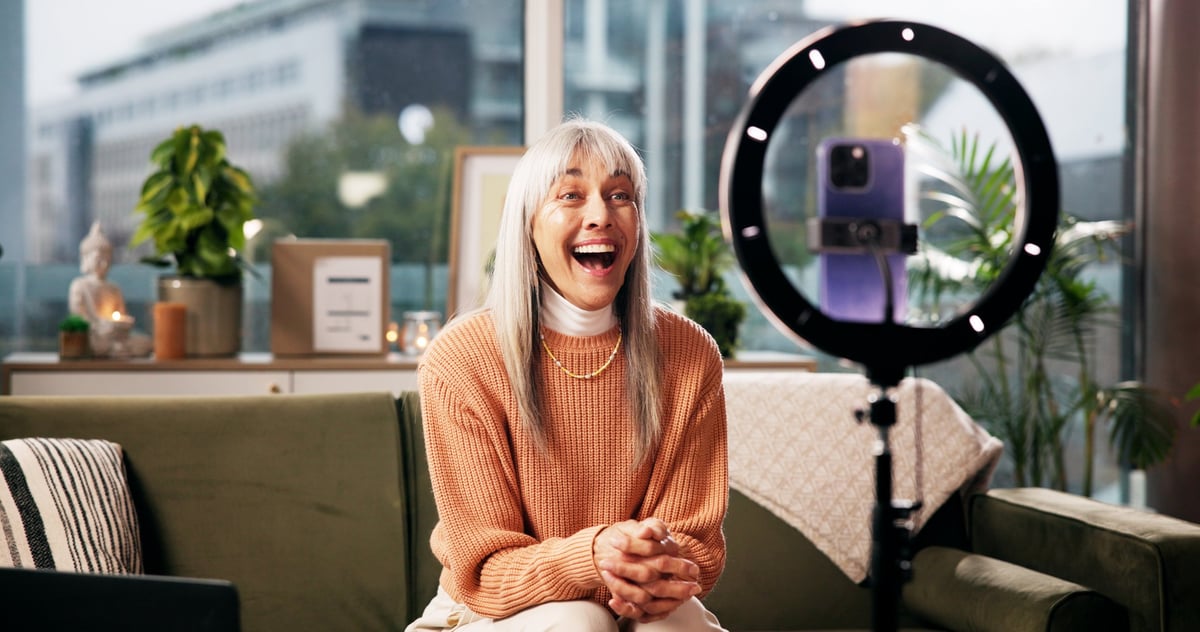 Content creator engaging with her online audience while filming social media content at home