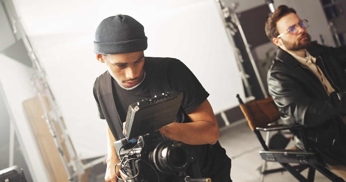 Video production crew filming brand content with a professional camera in a studio